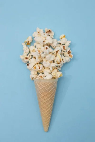 薄い青の背景にコーンにポップコーンアイスクリーム ミニマル フラット シーン — ストック写真