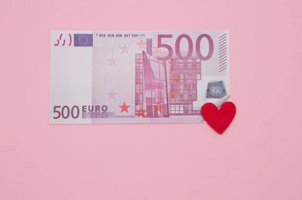 500 Euro 'luk banknot ve pembe arka planda kırmızı kalp..