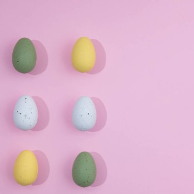 Değişik renklerde Paskalya yumurtaları. Pembe arka planda hafif gölgeler ve fotokopi alanı. En az Paskalya sahnesi.