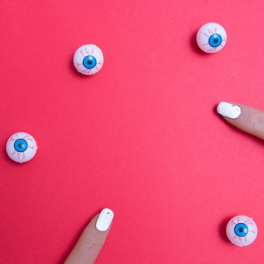 Ürkütücü gözler, ürkütücü parmaklar ve fotokopi alanı olan kırmızı bir arka plan. En az düz sahne.