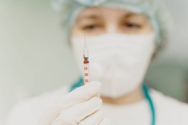 Doktor elinde enjeksiyonlu bir şırınga tutuyor. Seçili Odaklanma