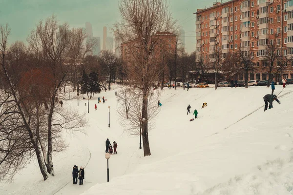 MOSCOW, RUSSIA - 26 grudnia 2021 r.: Rury saneczkowe i zjeżdżalnie w niedzielę. Dzieci wspinają się na strome zbocze — Zdjęcie stockowe