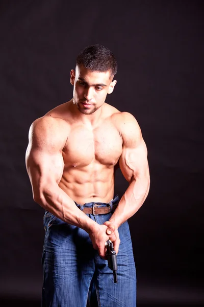 Bodybuilder with gun — Stock Photo, Image