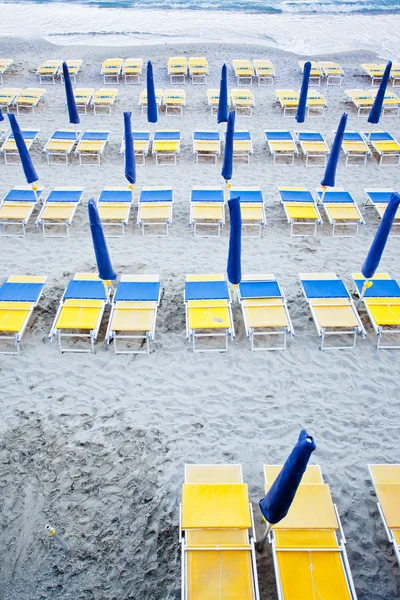 Guarda-chuvas de praia com cadeiras — Fotografia de Stock