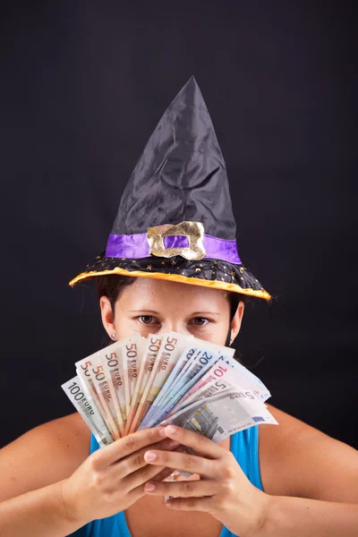 Hexe zeigt Geld — Stockfoto