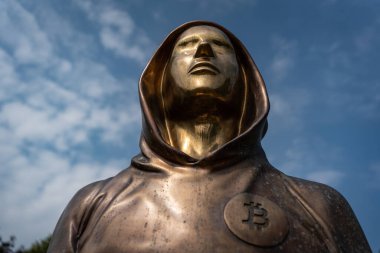 Budapest, Hungary -August 7, .2022:  Portrait of the statue of Satoshi Nakamoto mysterious founder of Bitcoin and Blockchain technology in; created by Reka Gergely and Tamas Gilly.  August 7, .2022 in Budapest, Hungary.