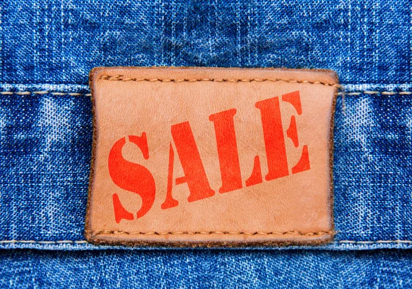 Closeup jeans etiqueta de couro com venda de texto — Fotografia de Stock
