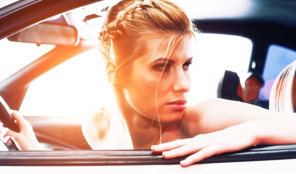 Mujer joven sentada en el asiento de los conductores de su coche — Foto de Stock