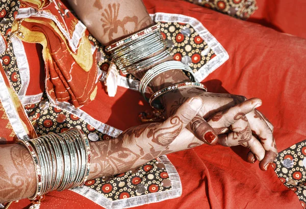 Mãos de uma jovem mulher indiana adornada com pulseiras tradicionais e mehndi . — Fotografia de Stock