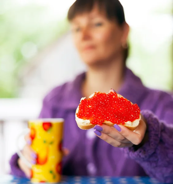 Frau mit rotem Kaviar-Sandwich — Stockfoto