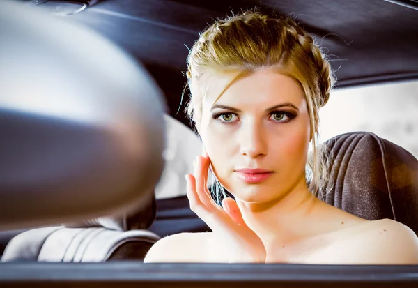 Young woman looking in rear view mirror car — Stock Photo, Image