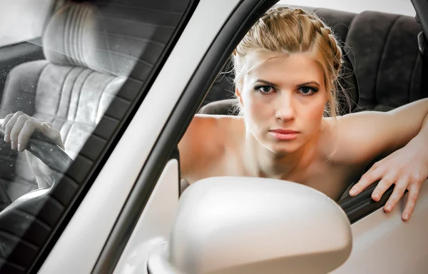Mujer joven sentada en el asiento de los conductores de su coche — Foto de Stock