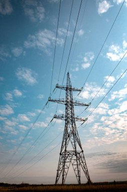 Akşam gökyüzü arkaplanındaki elektrik hatları