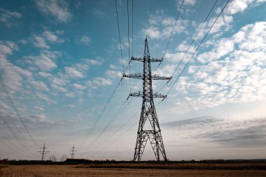 Akşam gökyüzü arkaplanındaki elektrik hatları