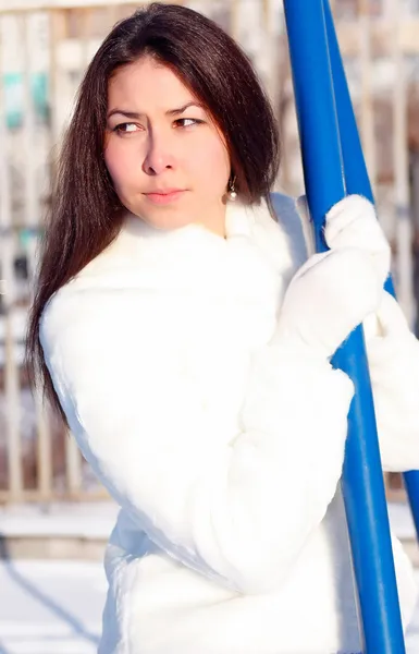 Beautiful girl with long hair in a white fur coat — Stock Photo, Image