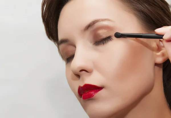 Vacker kvinna med ljusa makeup och borste — Stockfoto