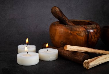 palo santo and mortars in front of dark background