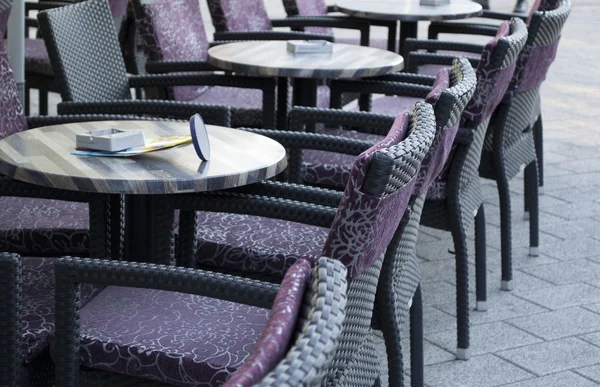 Vista a la calle de una terraza de café vacía con mesas y sillas —  Fotos de Stock