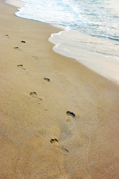 Stampe di piedi su una spiaggia di sabbia — Foto Stock