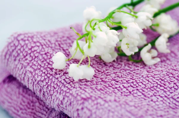 Spa setting of  towels, soap and lilies of the valley — Stock Photo, Image