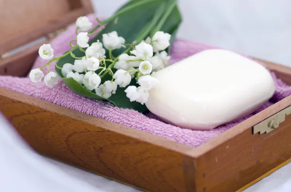 Ambiente de spa de toalhas, sabão e lírios do vale — Fotografia de Stock