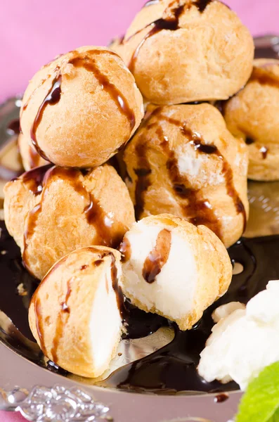 Profiteroles with chocolate syrup — Stock Photo, Image