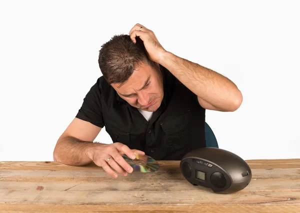 Kerl versucht, eine CD in einen digitalen Audio-Player zu legen — Stockbild Kampf mit der Technologie — Stockfoto