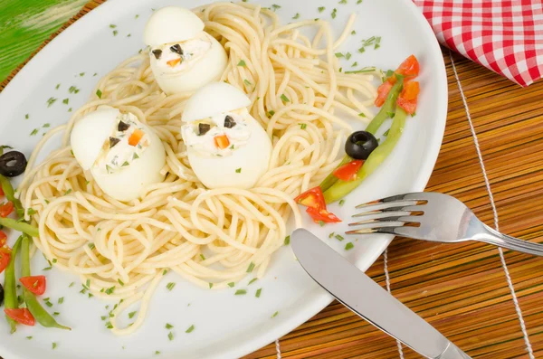 Eggs in a pasta nest — Stock Photo, Image