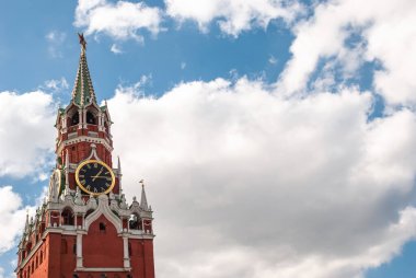Moskova Kremlin 'in Spasskaya Kulesi. Moskova bulutlu mavi gökyüzünün arka planında çan çalıyor.