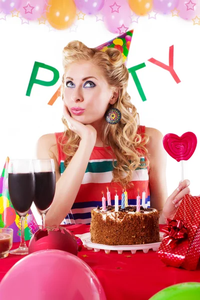 Verrast pinup meisje zit op party tafel met baloons — Stockfoto