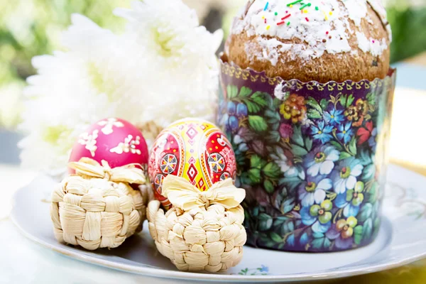 Velikonoční dort s barevnými vejci a květiny — Stock fotografie