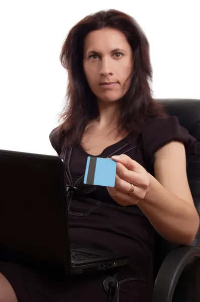 Serious woman holding credit card with laptop — Stock Photo, Image