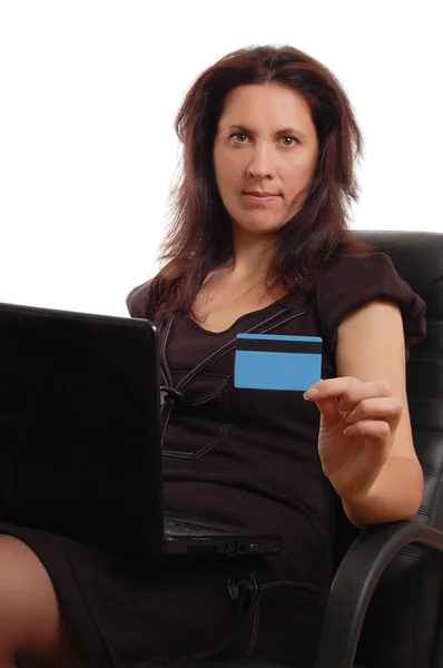 Mujer seria sosteniendo tarjeta de crédito con ordenador portátil — Foto de Stock