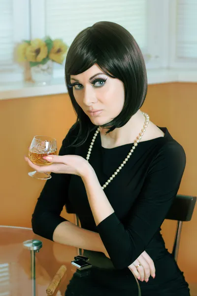 Frau im Retro-Stil mit einem Glas Cognac — Stockfoto