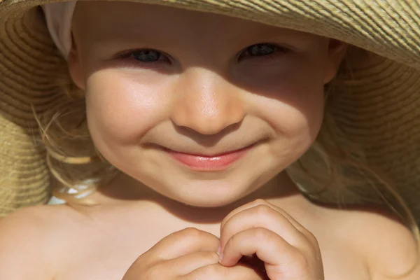 Baby meisje gezicht zonovergoten onder hoed — Stockfoto