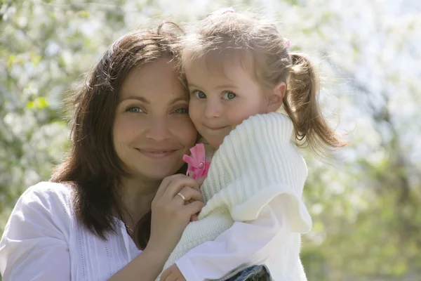 Glückliche Mutter und kleines Mädchen im Garten — Stockfoto