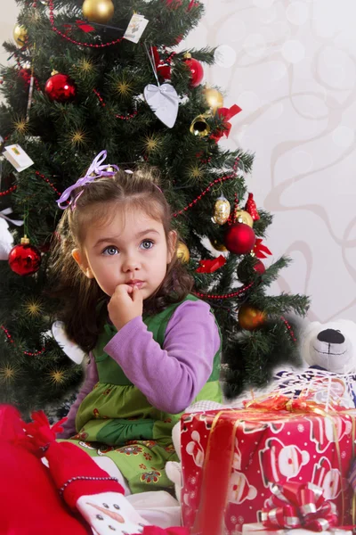 Little girl under Christmas tree with gifts Royalty Free Stock Images