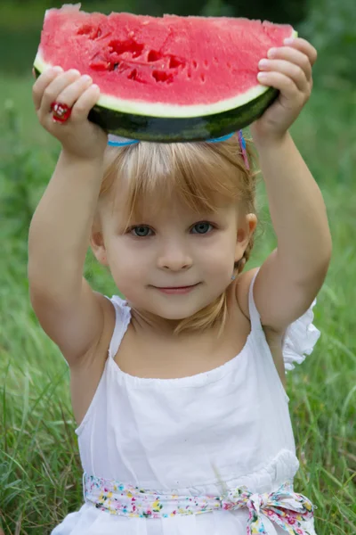 Klein meisje segment van watermeloen buiten bedrijf — Stockfoto