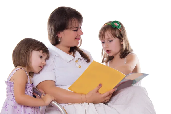 听他们的母亲阅读书的两个女儿 — 图库照片