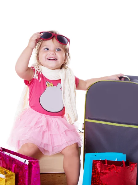 Gelukkig babymeisje met glazen en koffer — Stockfoto