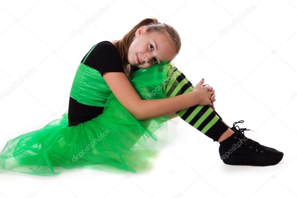 Little dancer in green tutu skirt sitting