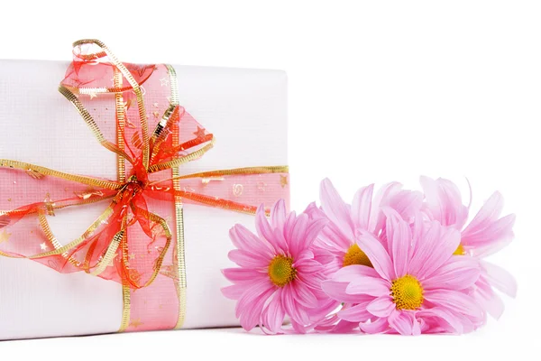 Caja de regalo con cinta roja y dasias rosadas — Foto de Stock