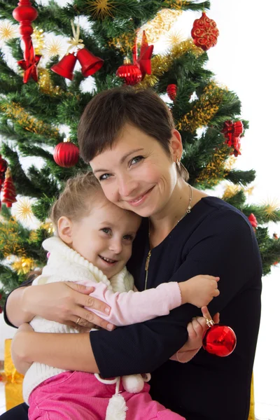 Matka vytěžený dcera pod vánoční stromeček — Stock fotografie