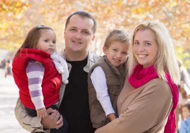 Sonbahar parkında iki çocuklu bir aile