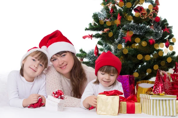 Madre y dos hijas bajo el árbol de Navidad — Foto de Stock