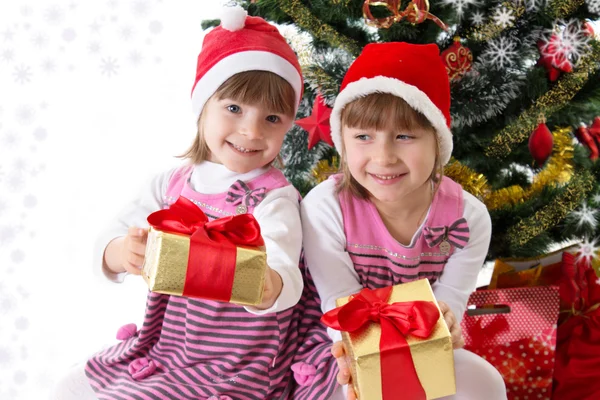 Petites sœurs avec des cadeaux sous le sapin de Noël — Photo