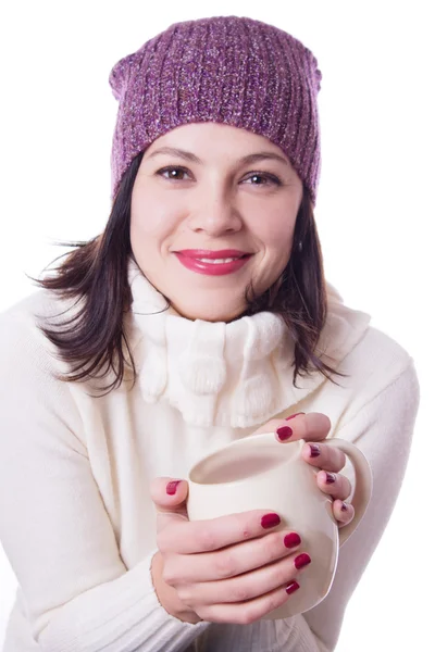 Улыбающаяся женщина в трикотажной шляпе держит чашку напитка — стоковое фото