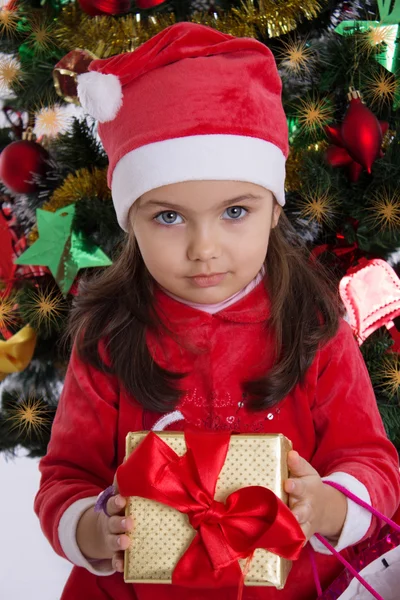 Girl in Santa hat holding Christmas gift — Stock Photo, Image