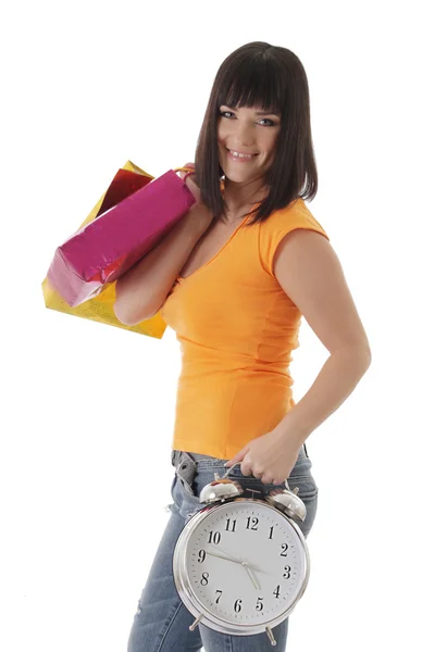 Smiling girl with shopping begs and clock — Stock Photo, Image