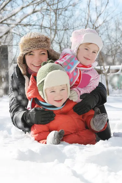 Мать с двумя детьми, лежащими в снегу — стоковое фото